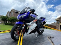 a blue and white motorcycle is parked on a flatbed truck