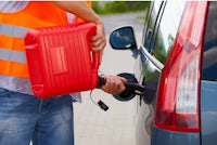 a man filling a gas can into a car