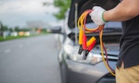 a man is working on a car with a jumper cable